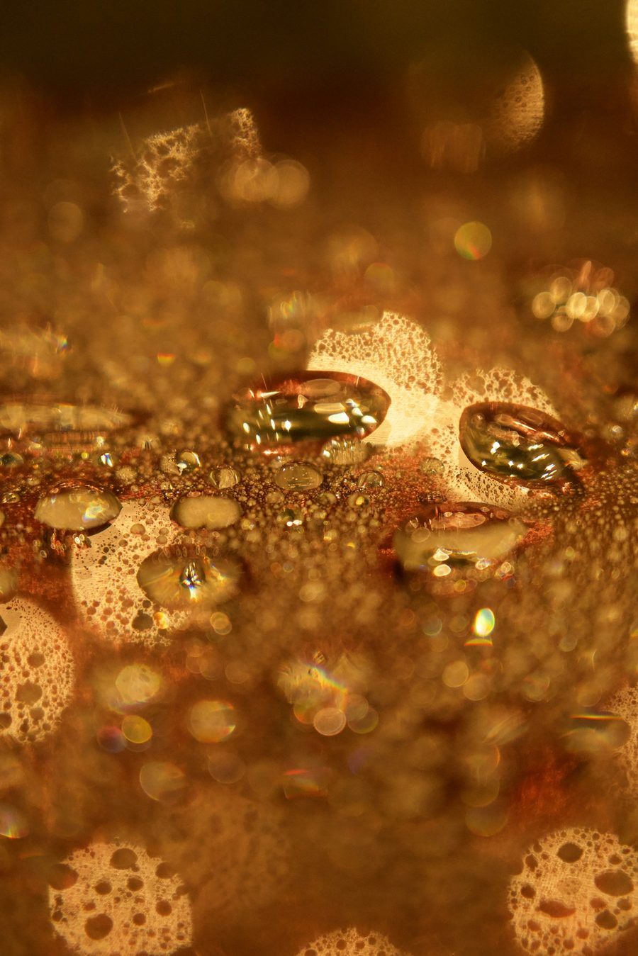 Macro de gotas doradas sobre una superficie ambarina
